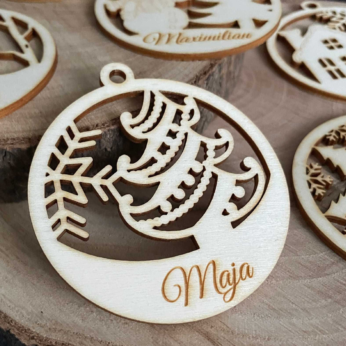 Holz-Weihnachtskugel mit Tannenbaummotiv und Name Maja auf einer Holzscheibe