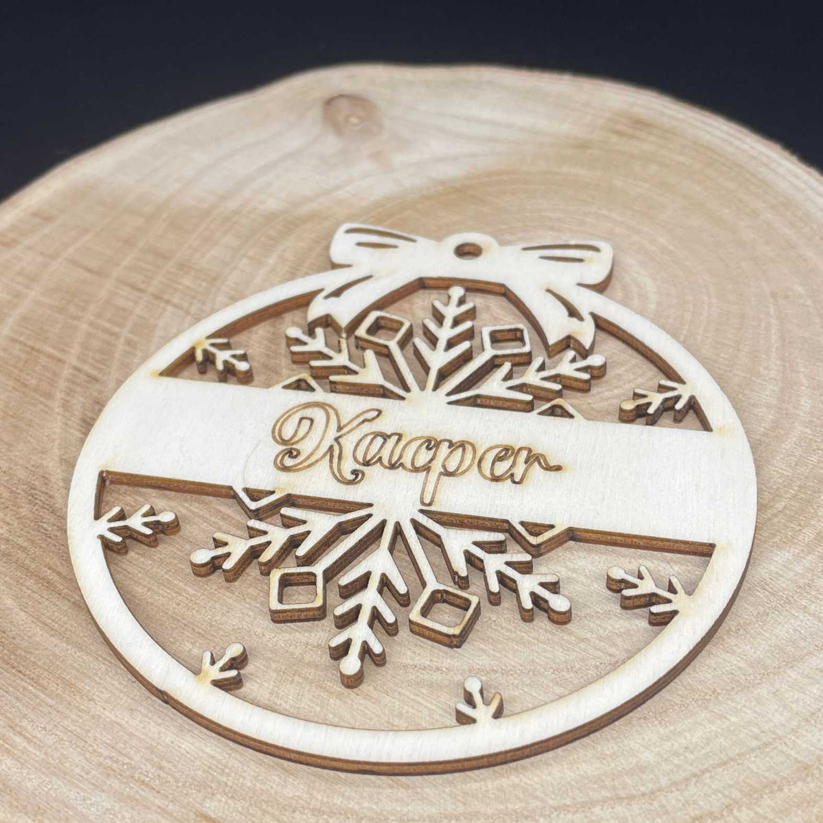 Personalisierte Holz-Weihnachtskugel mit Schneeflocke auf einer Holzscheibe